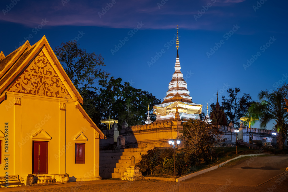 Naklejka premium Golden pagoda and chapel on hill or mountain to at Wat Phrathat Khao Noi temple during twilight, Nan province, Thailand