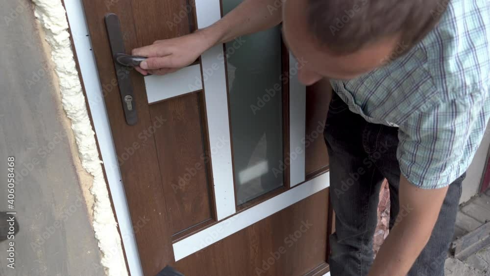 protective film on plastic frames doors,The man removes the protective film from the plastic frames after installation protective film on plastic frames doors,The man removes the protective film from the plastic frames after installation