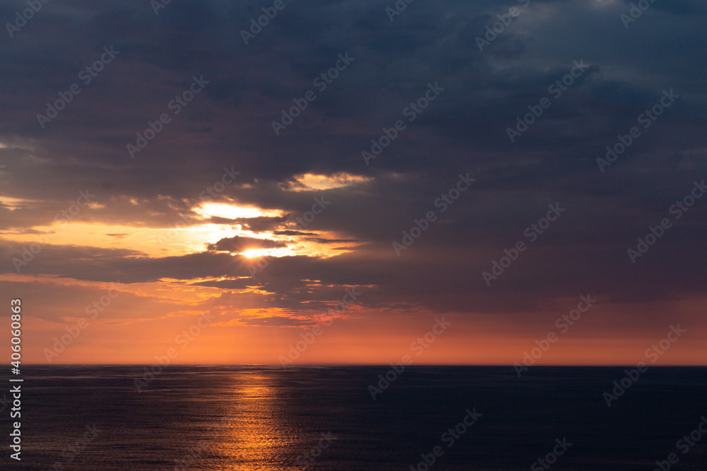beautiful orange sunset over the dark sea wit an orange line of reflection. Horizontal picture.