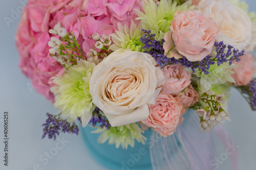Flower arrangement in a hat box. On a light background. Bouquet of light, delicate flowers.