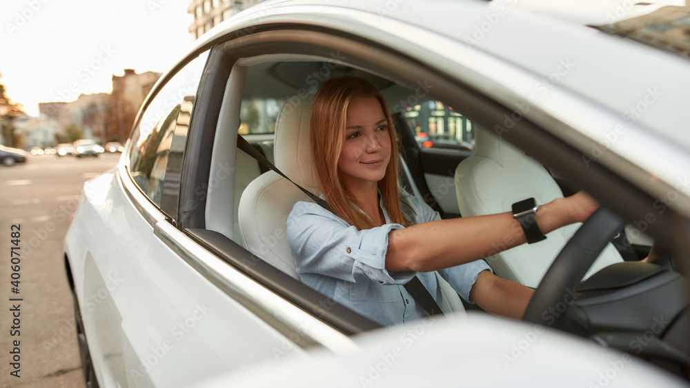 Young woman sitting on driver seat in car