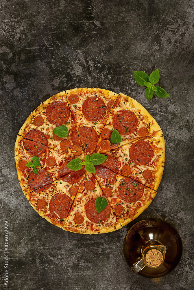 Tasty pepperoni pizza and fresh basil on dark background. Tasty pepperoni pizza and fresh basil on dark background.