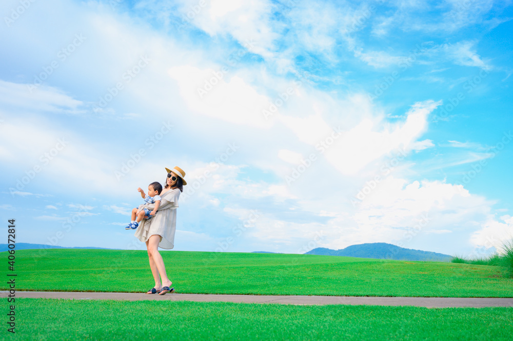 Mother and baby boy playing on the grass summer background with mum and child Mother and baby boy playing on the grass summer background with mum and child