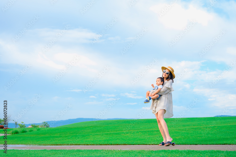 Mother and baby boy playing on the grass summer background with mum and child Mother and baby boy playing on the grass summer background with mum and child