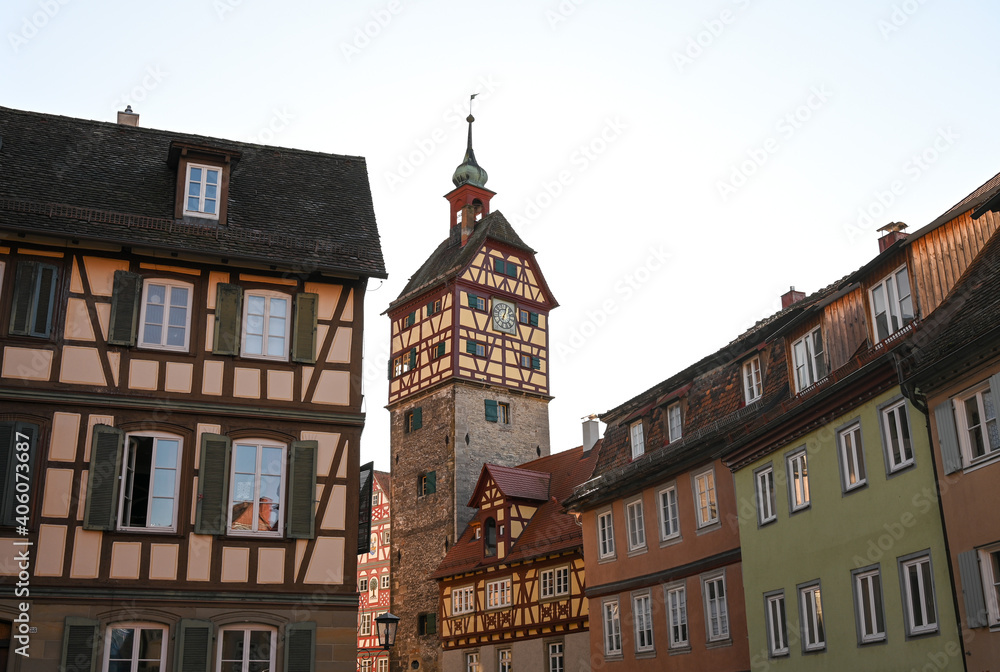 Historical half-timbered houses and the Josenturm tower in the old town of Schwäbisch Hall, Germany under a clear blue sky.