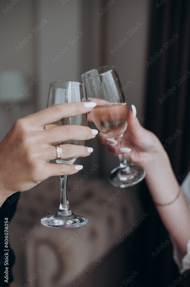 two women's hands with champagne glasses in their hands