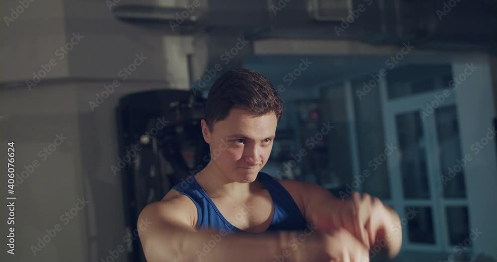 The athlete doing circular movements of arms and tilts head in gym The athlete doing circular movements of arms and tilts head in gym