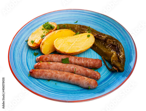 Appetizing grilled sausages served with baked potato, pepper and herbs. Isolated over white background