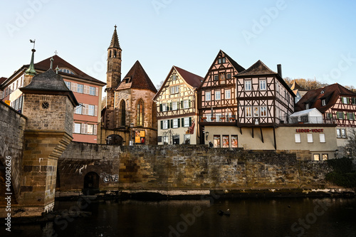 Cityscape of Schwäbisch Hall, Germany showing colorful half-timbered houses and and a historical bell tower of a church.