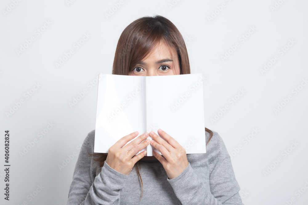 Young Asian woman with a book cover her face. Young Asian woman with a book cover her face.
