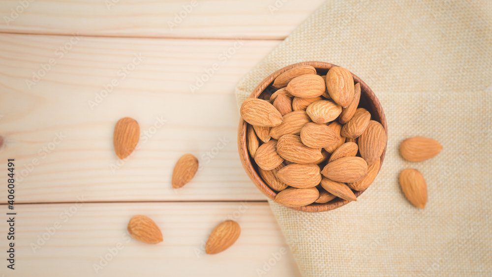 Almonds raw peeled in brown wooden bowl on wooden table background.Healthy food Concept Almonds raw peeled in brown wooden bowl on wooden table background.Healthy food Concept