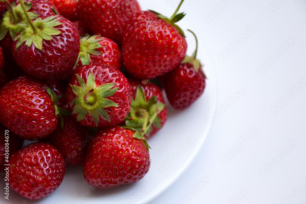 Strawberries on white plate. Freshly picked strawberry. Organic berries on white background. Village garden harvest. Strawberries on white plate. Freshly picked strawberry. Organic berries on white background. Village garden harvest.