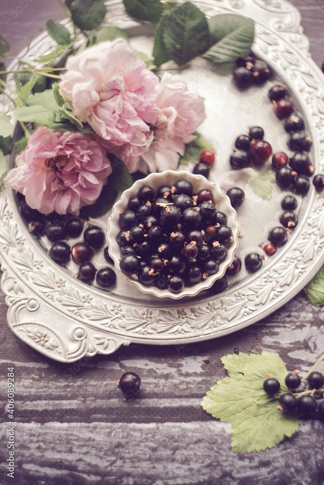 Damask rose, currants and rosehip flowers on an old vintage tray, garden roses, garden still life Damask rose, currants and rosehip flowers on an old vintage tray, garden roses, garden still life