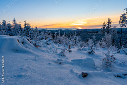 Frosty winter sunrise in mountain foresty with snow covered fir trees. Great outdoor scene, Happy New Year celebration concept. Artistic style post processed photo. Orton Effect.