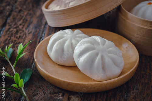 Steamed pork buns on wooden plate, Chinese dim sum .