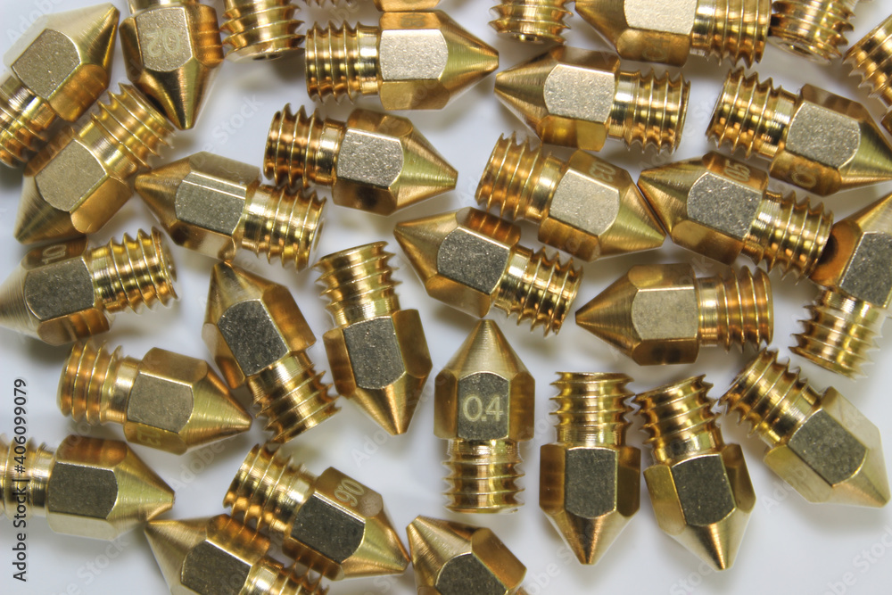 Many 3d printer brass nozzles on white background. Additive technology component. Many 3d printer brass nozzles on white background. Additive technology component.