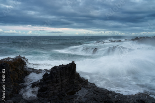 Scenic view of the North coast of Gran Canaria and waves breaking against dark rocks photo