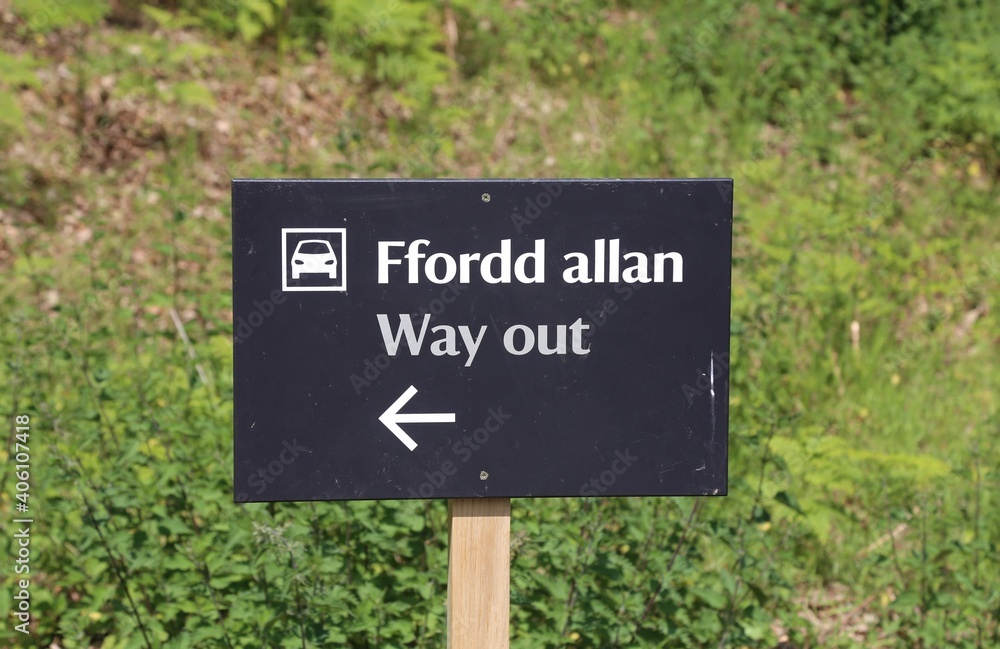 A bilingual sign informing people of the way out of a Welsh car park.
