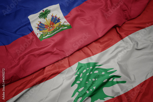 waving colorful flag of lebanon and national flag of haiti. photo