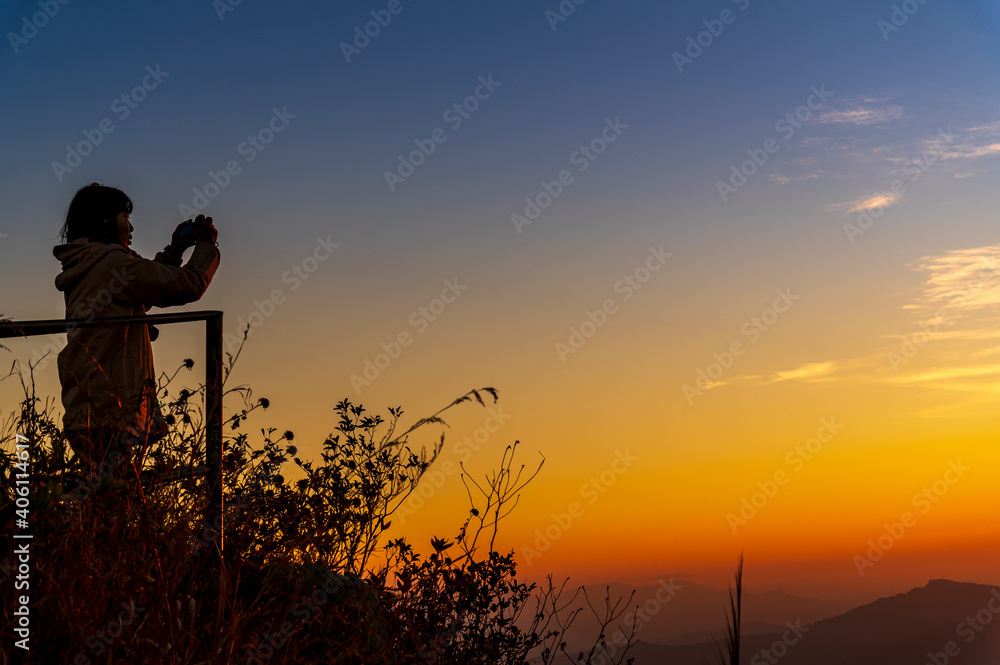 Tourist take photo the Landscape of the mountain and sea of mist in winter sunset / sunrise view from top of Doi Pha Tang mountain , Chiang Rai, Thailand
