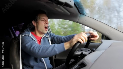 Sleepy driver yawns and closes eyes while driving in car. Yawning and fatigue are danger from traffic accident
