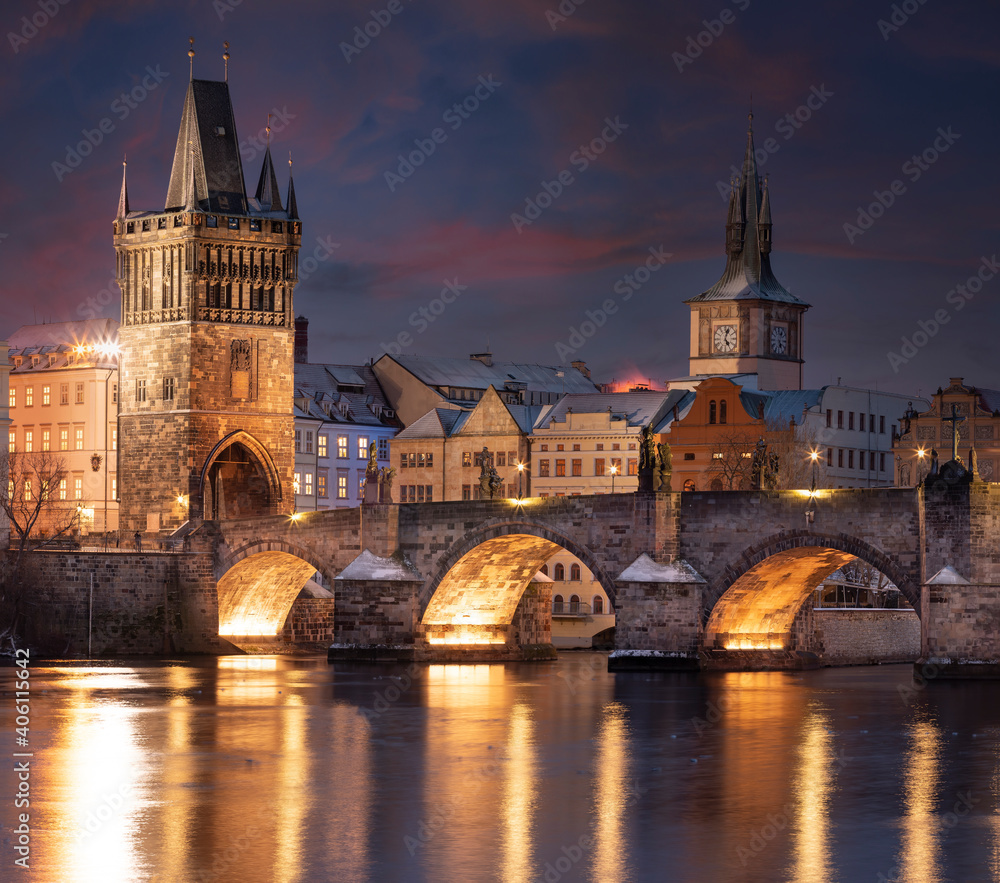 .Charles Bridge on the Vltava River and statues on the bridge and light from the street lights and a fallen dream in winter in the early evening in the center of Prague