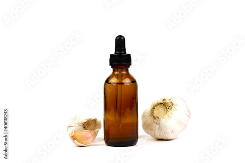 Garlic oil in bottle and fresh garlic isolated on white background.
