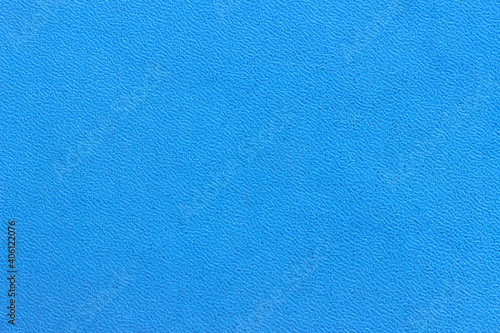 The surface of the blue old worn dermatin with a small pattern.