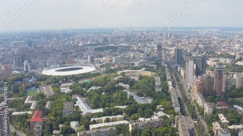 Stadium in a green city, a terrible sky and the sun's rays. Kyiv, Ukraine - Cityscape Aerial Flight