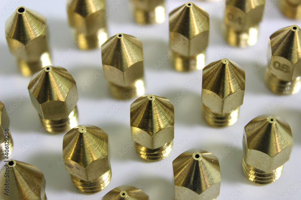 3d printer brass nozzles in a row or array on white background. Additive technology component. 3d printer brass nozzles in a row or array on white background. Additive technology component.