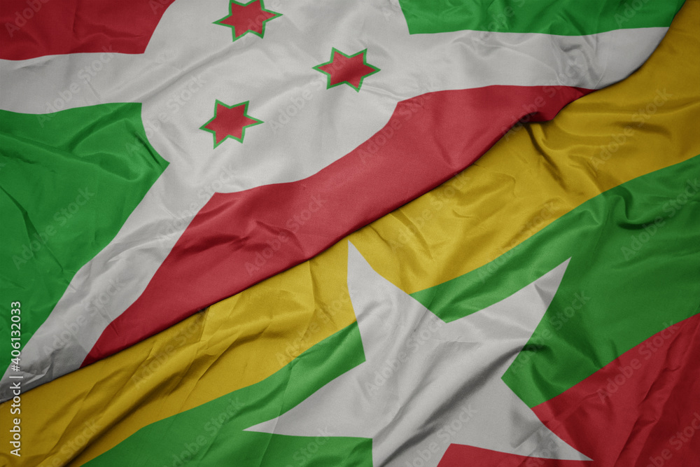 waving colorful flag of myanmar and national flag of burundi .