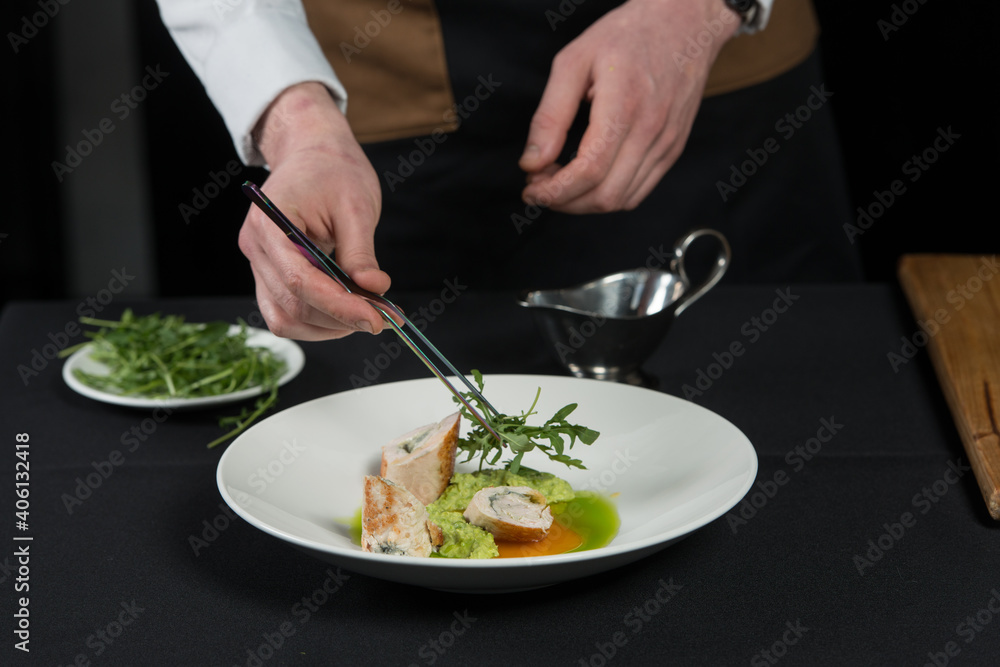 The chef prepares a serving of meatloaf. Putting Arugula over the dish