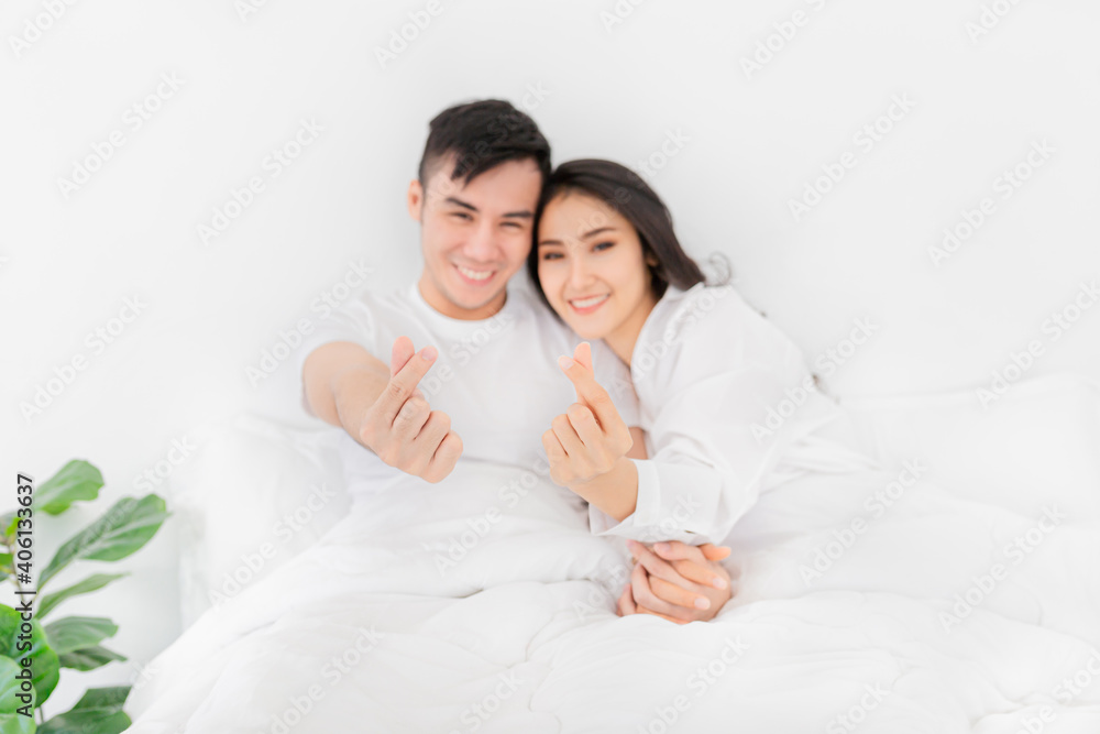 close up hands, Asian lover show heart sign with hands, they rest on white bed, they feeling happy and smiling, happiness honeymoon and valentine's day close up hands, Asian lover show heart sign with hands, they rest on white bed, they feeling happy and smiling, happiness honeymoon and valentine's day
