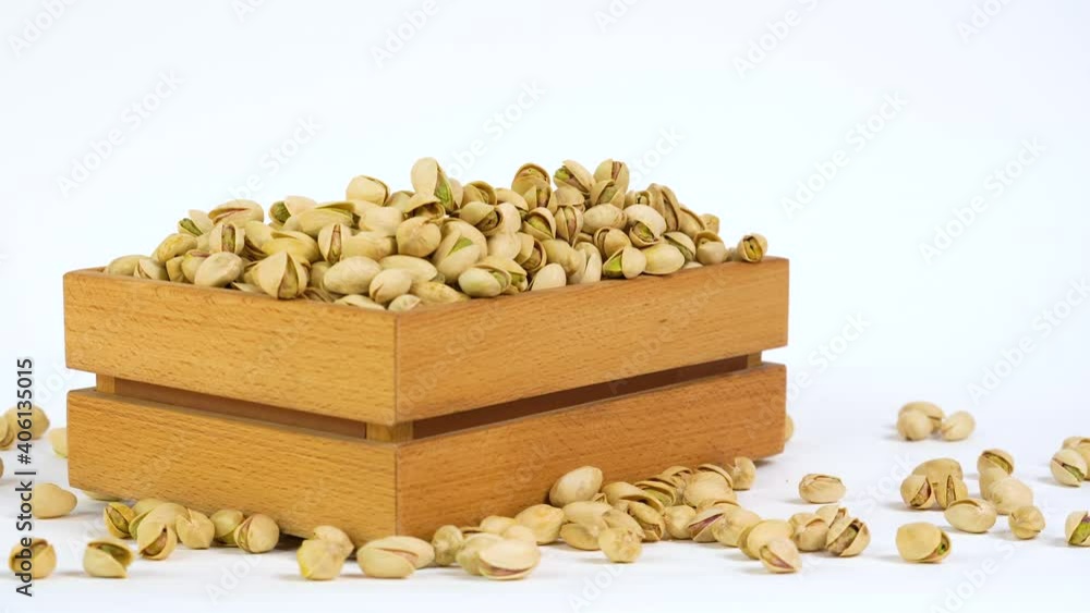 Pistachio nuts on white background. Nuts in wooden box. Product for sale. Products show for sale. Fresh roasted pistachio nuts isolated on white. Slider shot. Free space for text. Pistachio nuts on white background. Nuts in wooden box. Product for sale. Products show for sale. Fresh roasted pistachio nuts isolated on white. Slider shot. Free space for text.