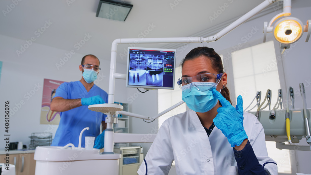 Doctor specialist talking with patient in stomatology clinic, sitting on chair before examination. Stomatologist explaining dental problem and treatment dentistry prevention wearing protection mask Doctor specialist talking with patient in stomatology clinic, sitting on chair before examination. Stomatologist explaining dental problem and treatment dentistry prevention wearing protection mask