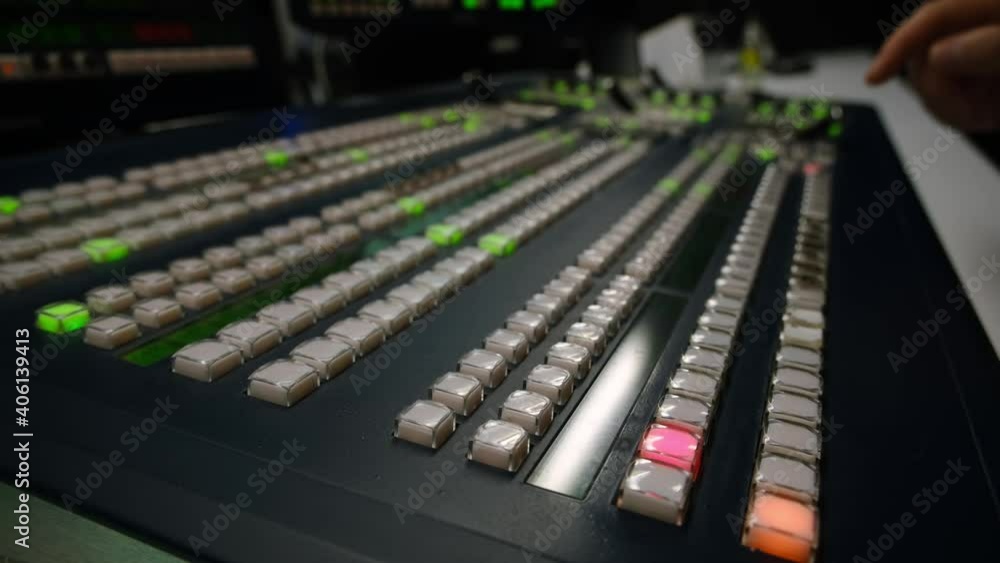 Broadcast Tv Studio Production - Vision Switcher Studio Director broadcast video mixer operation - Close-up of hand. Hands of a cinematographer who worked on the vision mixer, switch the TV panel. Broadcast Tv Studio Production - Vision Switcher Studio Director broadcast video mixer operation - Close-up of hand. Hands of a cinematographer who worked on the vision mixer, switch the TV panel.