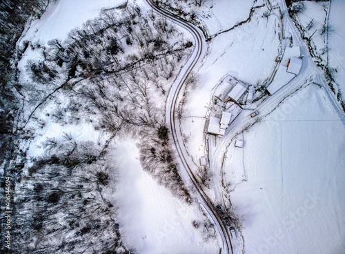 Drone overhead shot of curved road in winter mountain landscape. photo