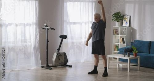 Wallpaper Mural morning gymnastics of middle-aged man, caring about health, training alone in living room Torontodigital.ca