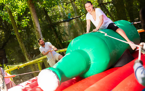 Fotografie Fun attraction - woman trying to stay on an inflatable bottle