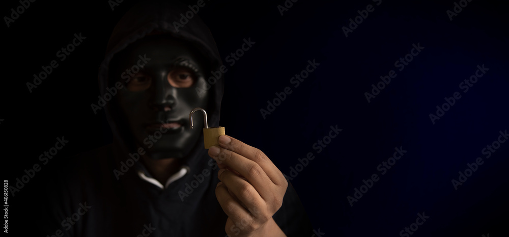 Hacker with black mask holding open lock. Concept of cyber security, cyber attack, phishing. Hacker with black mask holding open lock. Concept of cyber security, cyber attack, phishing.
