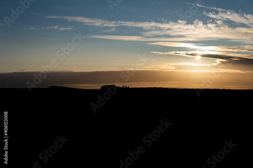 Friends silhouette enjoying a sunset in the Peak District middle