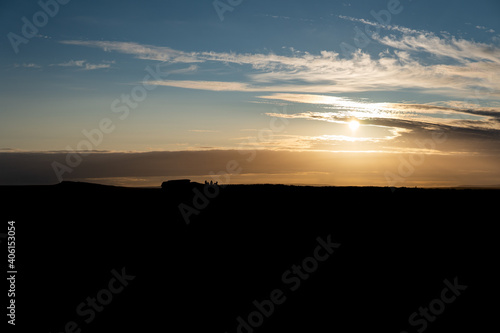 Friends silhouette enjoying a sunset in the Peak District left side