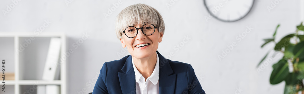 cheerful team leader in glasses smiling in office, banner cheerful team leader in glasses smiling in office, banner