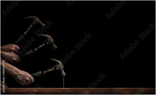 Fotografija A horizontal stroboscopic image of a man hammering a nail into a piece of wood