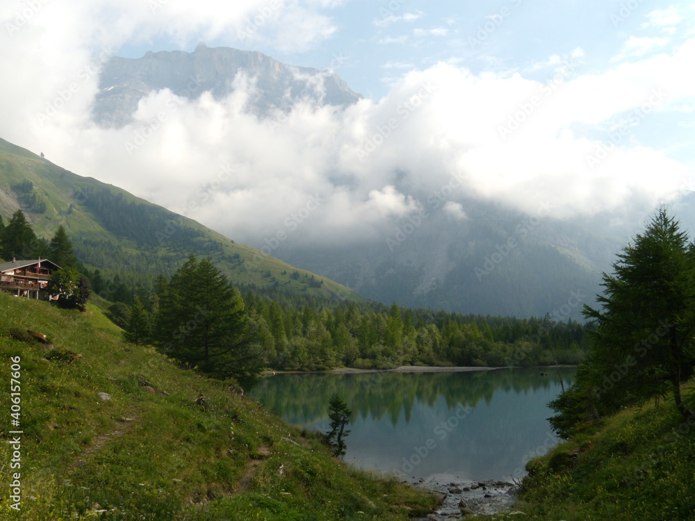 Vallée de Derborence en Suisse. Lac de montagne entouré de sapins- Ciel et nuages.