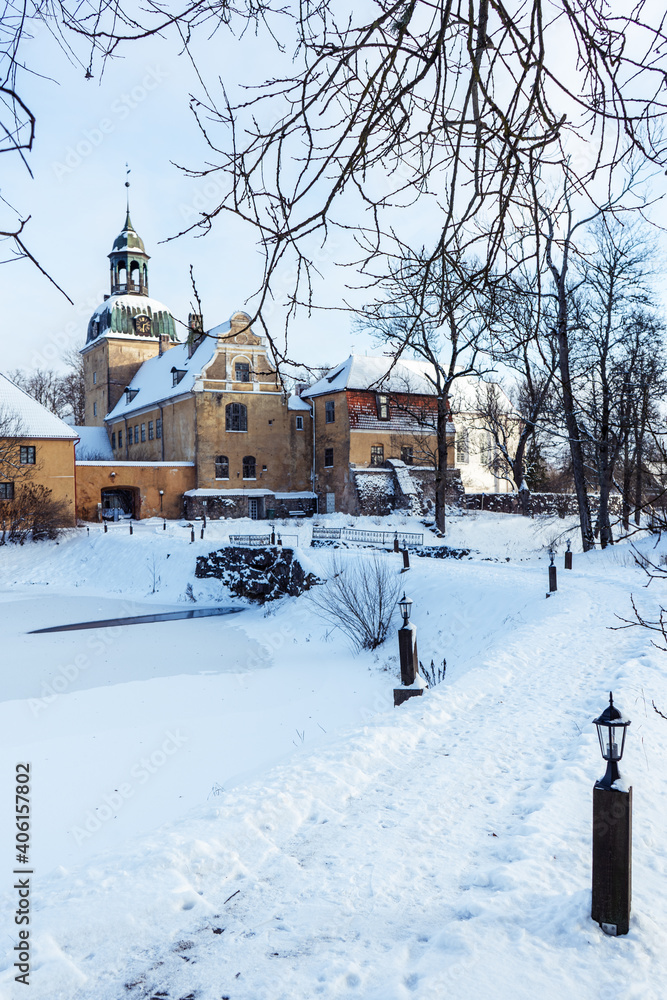 The building complex of an old large German manor located in Latvia is snow-covered in winter