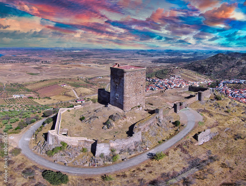 High angle shot of an old fortress tower, fields, and residential areas under the cloudy sky photo