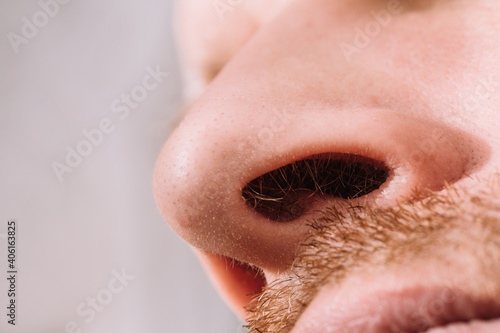 Male nose close up bottom view - hair in the nostrils