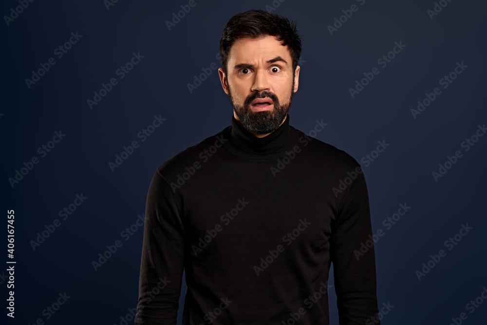 Freak-out shocked handsome bearded man, cringe from something disgusting or awful, grimacing alarmed, frowning make troubled, frustrated expression, standing worried over Pacific Blue background