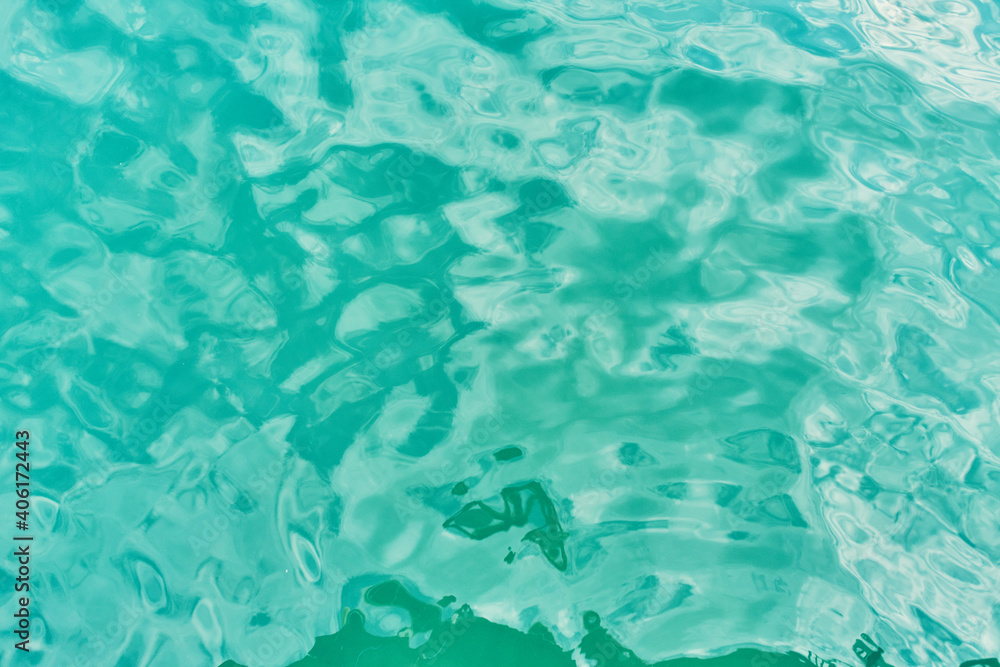 Water texture. Beautiful blue water ripple at the ocean. Light sea waves. Azure water in the pool.